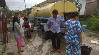 Karyawan PDAM Tirtauli sedang mengantar air ke pelanggan di Perumahan Batu Permata